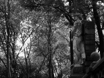 Low angle view of statue against bare trees