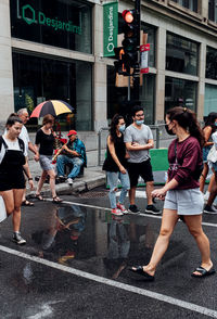 Group of people walking on road in city