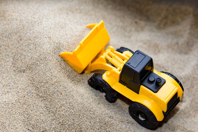 High angle view of toy bulldozer on sand