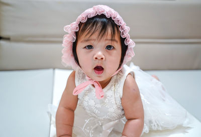 Portrait of cute girl standing against wall