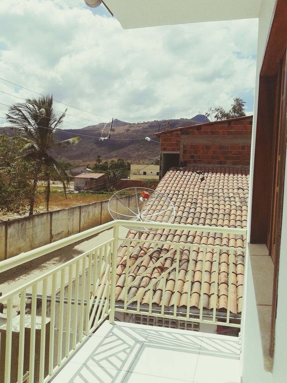 architecture, built structure, building exterior, sky, cloud - sky, house, railing, roof, cloudy, cloud, the way forward, residential structure, day, mountain, outdoors, residential building, no people, tree, diminishing perspective, nature