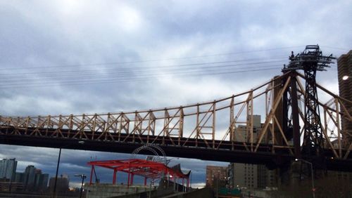 Low angle view of bridge against cloudy sky