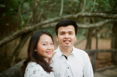 Portrait of smiling young man against trees