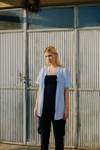 Portrait of woman standing against metal structure