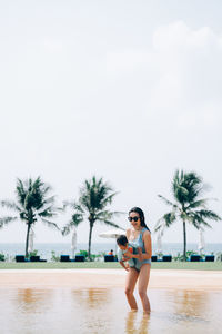 Full length portrait of young woman in swimming pool