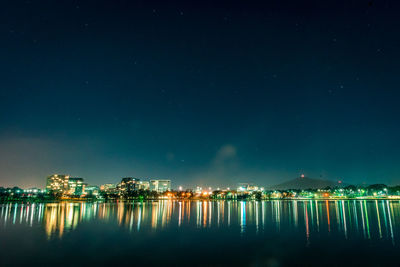 Illuminated city against sky at night