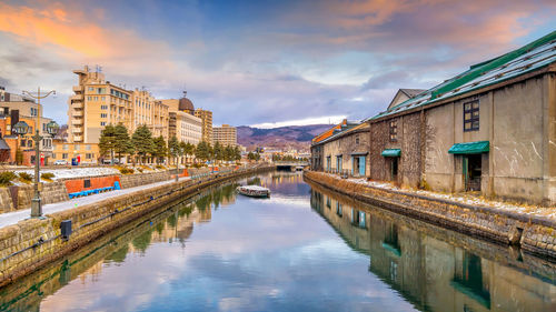 Canal amidst buildings against sky