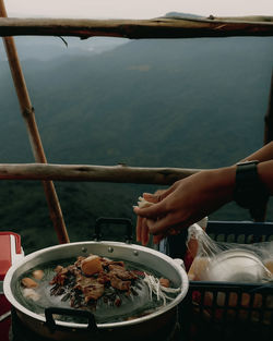 Man preparing food on table by sea