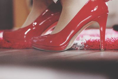 Low section of woman wearing red high heels