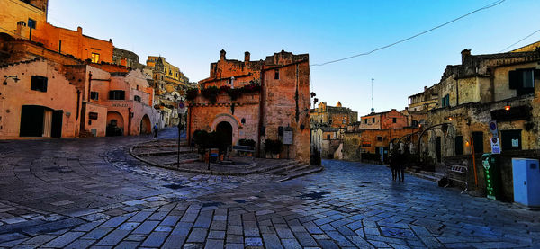 Street amidst buildings in town against sky