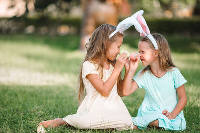Mother and girl sitting on field