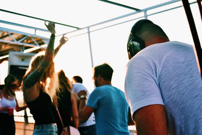 Dj playing music during party against people dancing