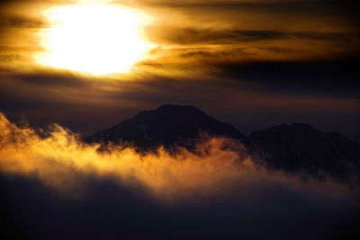 Scenic view of silhouette mountains against sky at sunset