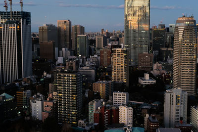 Aerial view of buildings in city against sky