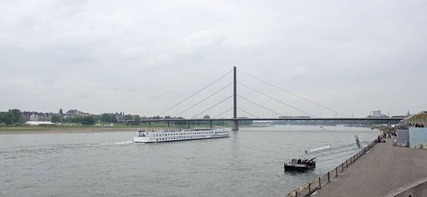 Bridge over calm river against sky