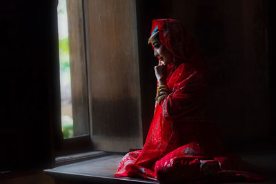 Side view of woman looking at camera