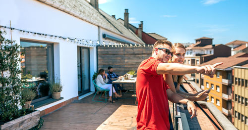 Happy couple looking mobile in work pause in office rooftop on a summer day