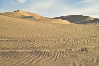 Sand dunes in desert against sky