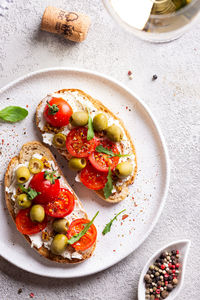 Bruschettas with olives and fresh tomatoes and wineglass