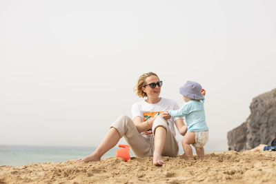 Full length of woman sitting on beach