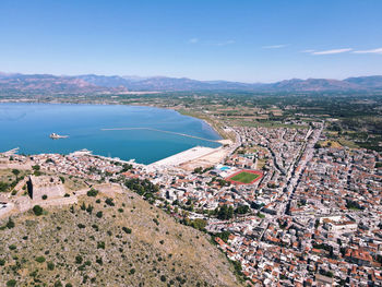 High angle view of townscape by sea against sky