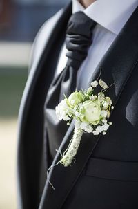 Midsection of man holding flower bouquet