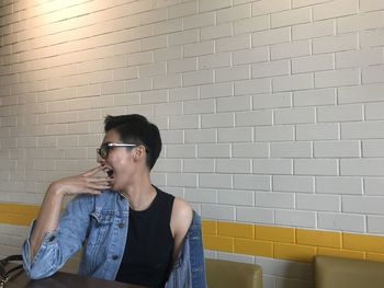 Young man standing against wall