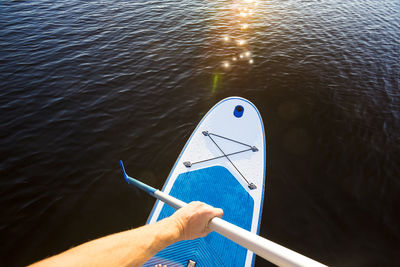 Close-up of hand holding boat in river