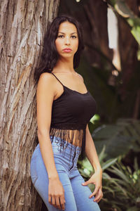 Portrait of a beautiful young woman with tree trunk