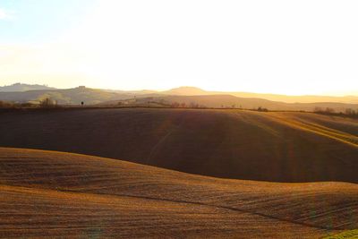 Scenic view of land against sky during sunset