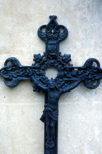 Close-up of cross sculpture against wall