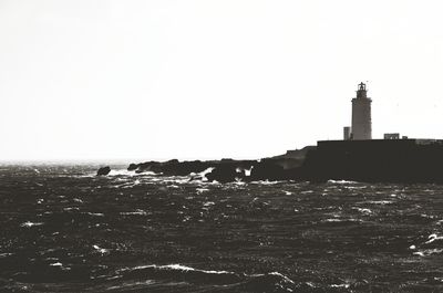 Built structure by sea against clear sky