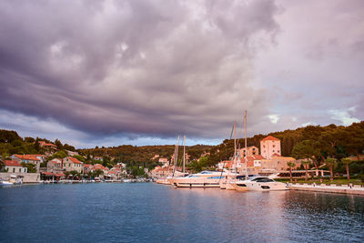 Boats in marina at harbor against sky