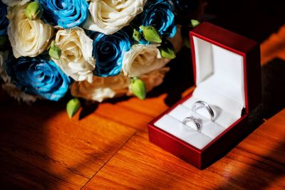 Cropped hand of woman with flowers on table