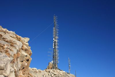 Low angle view of communications tower against clear blue sky