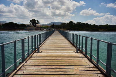 View of bridge over calm lake against sky