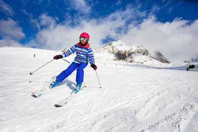 Full length of boy skiing on snow covered field