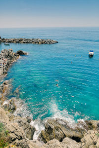 High angle view of rocks by sea against sky