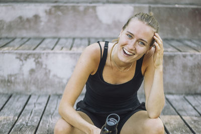 Portrait of happy woman laughing while sitting on steps