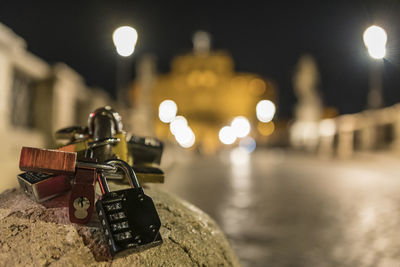 Close-up of padlocks on illuminated bridge