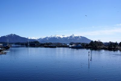 Scenic view of lake and mountains against blue sky