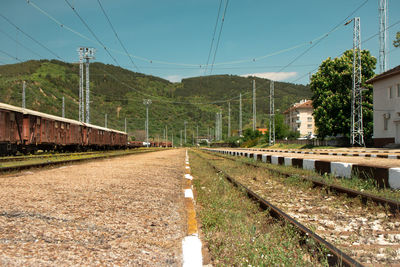 Railroad tracks by mountain against sky