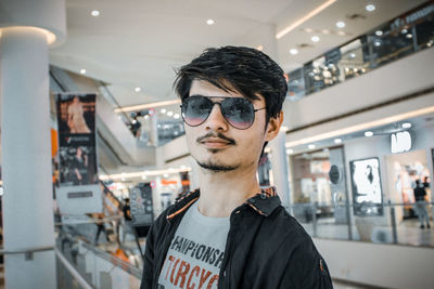 Portrait of young man standing in store