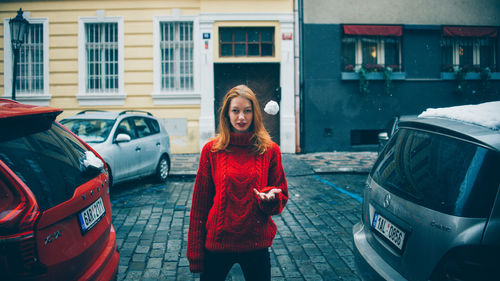 Portrait of smiling man standing by car in city