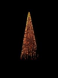 Illuminated christmas tree against sky at night