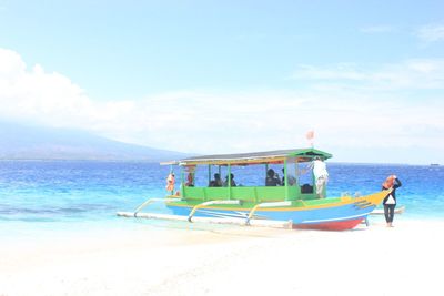 Deck chairs on beach against sky