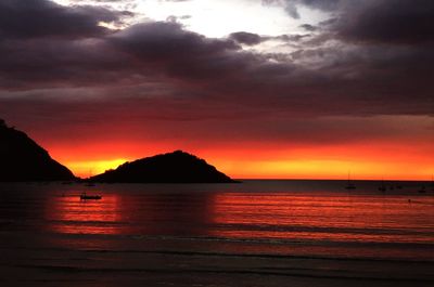 Scenic view of sea against dramatic sky during sunset