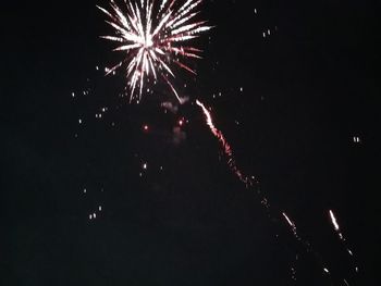 Low angle view of firework display at night