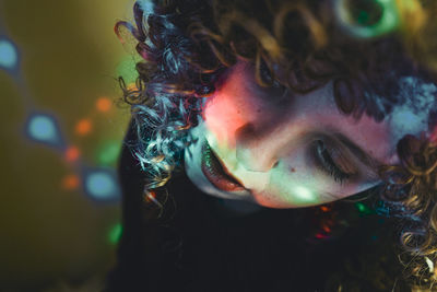 Close-up portrait of woman with multi colored lights