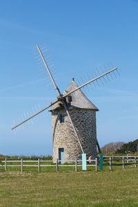 Traditional windmill on field against clear sky